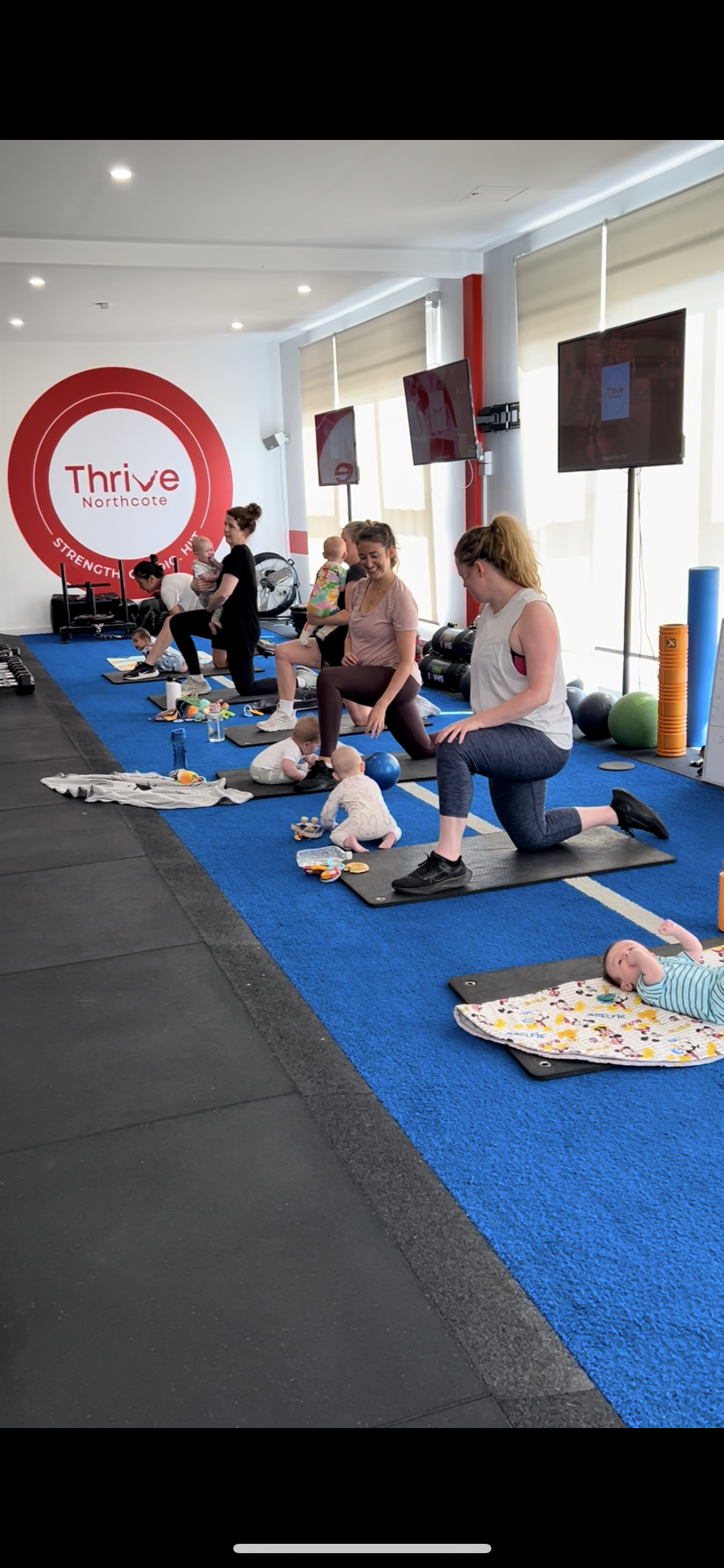 Children playing on mats in the Kids Zone while parents train at Thrive Northcote